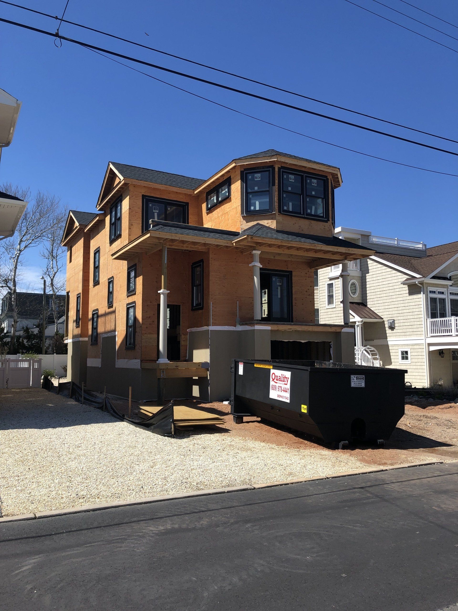 A large house under construction with a dumpster in front of it