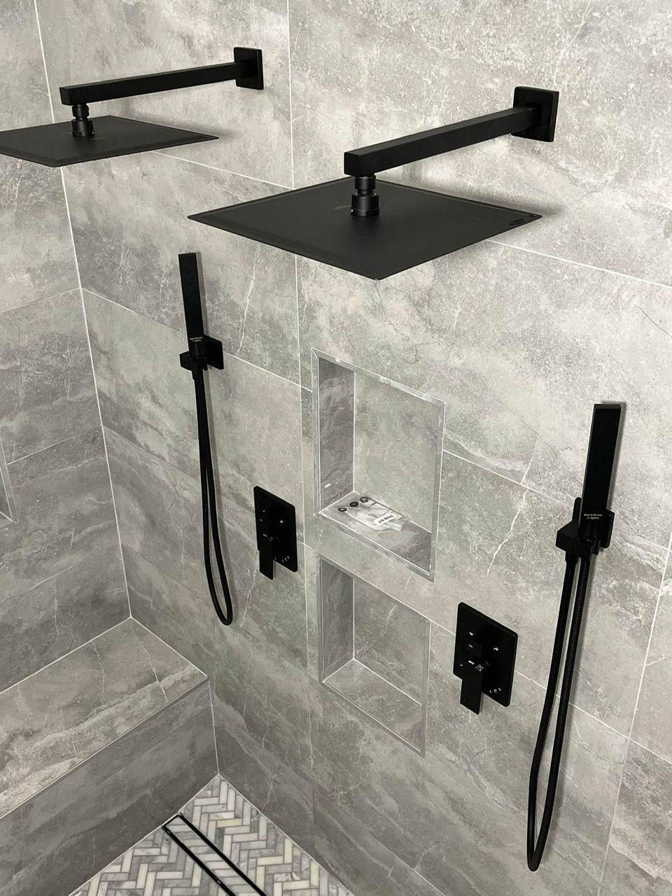 A shower area with two black shower heads
