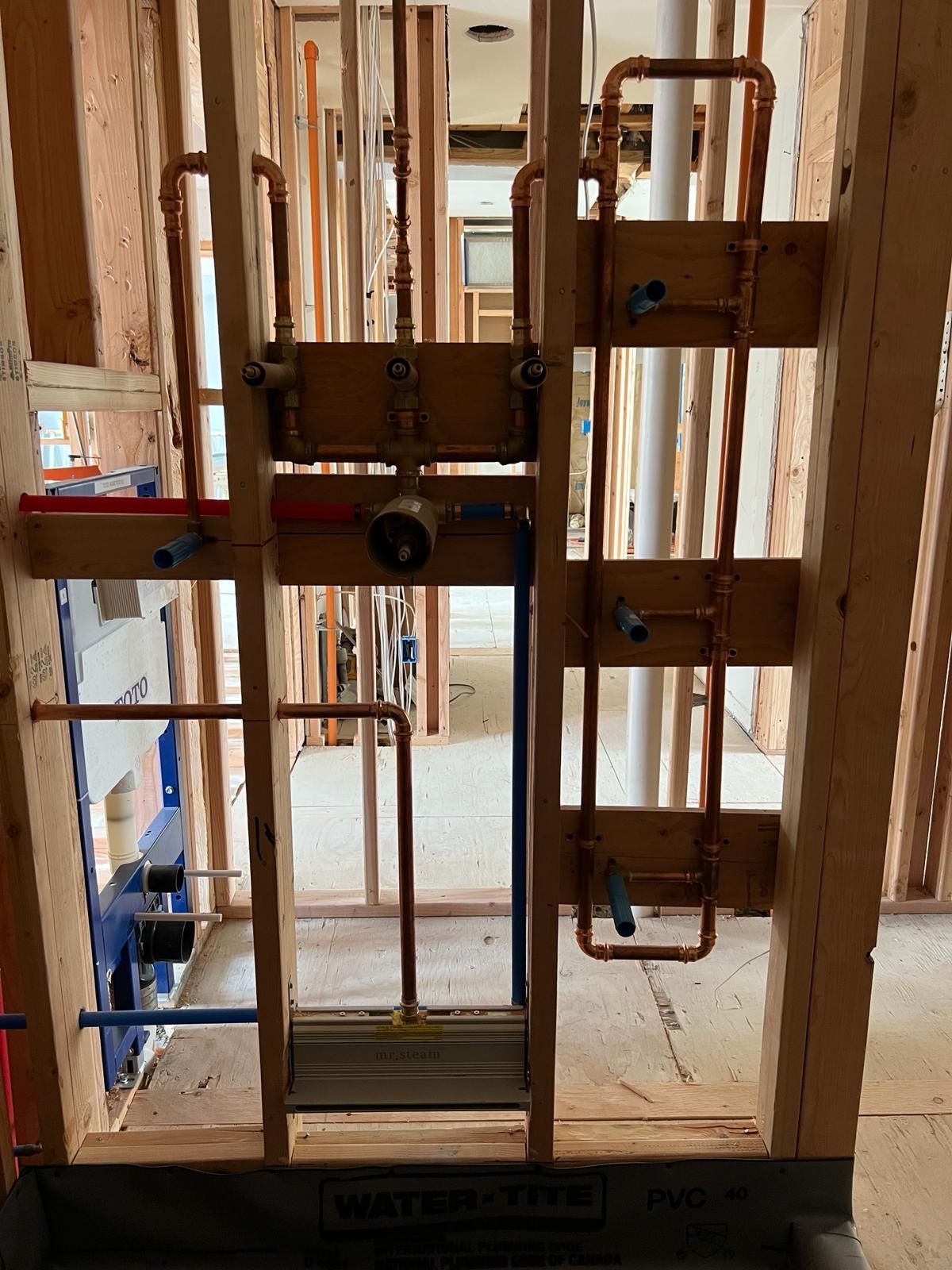 A room under construction with pipes for plumbing installations