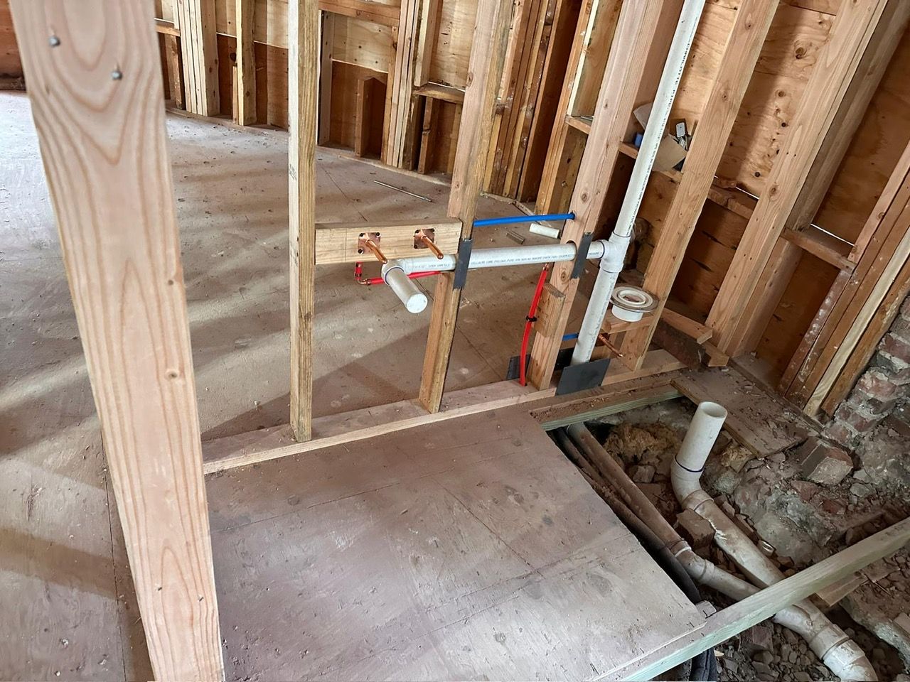 A bathroom under construction with pipes for plumbing