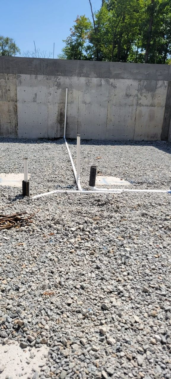 A gravel area with a concrete wall in the background