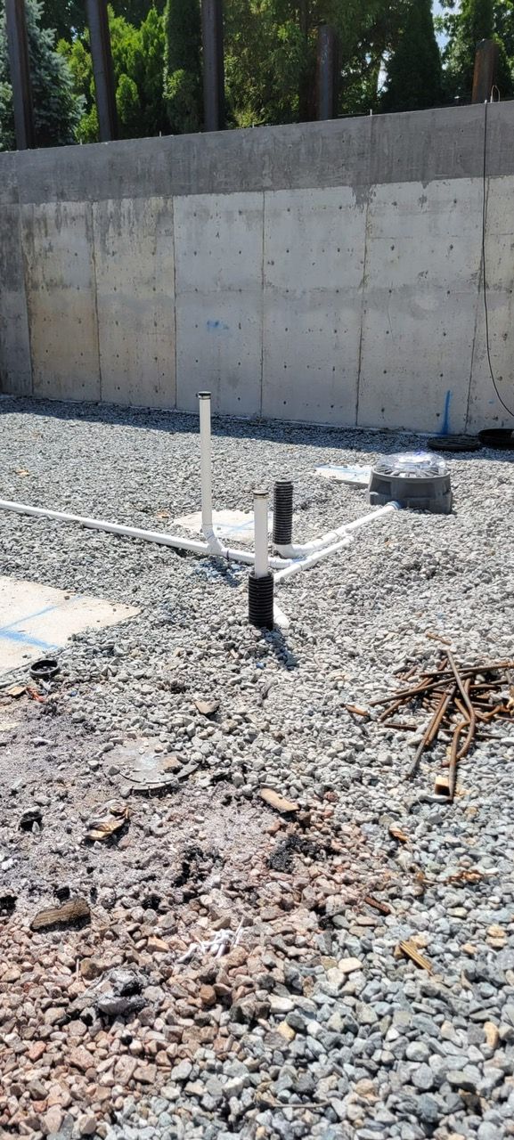 A gravel area with a concrete wall in the background