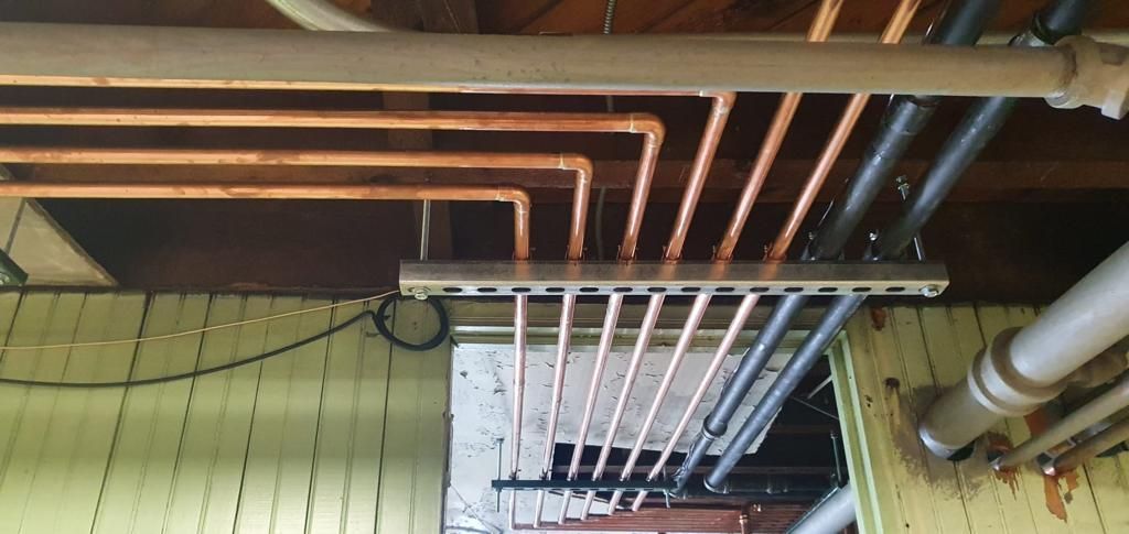 A bunch of pipes are hanging from the ceiling of a building.