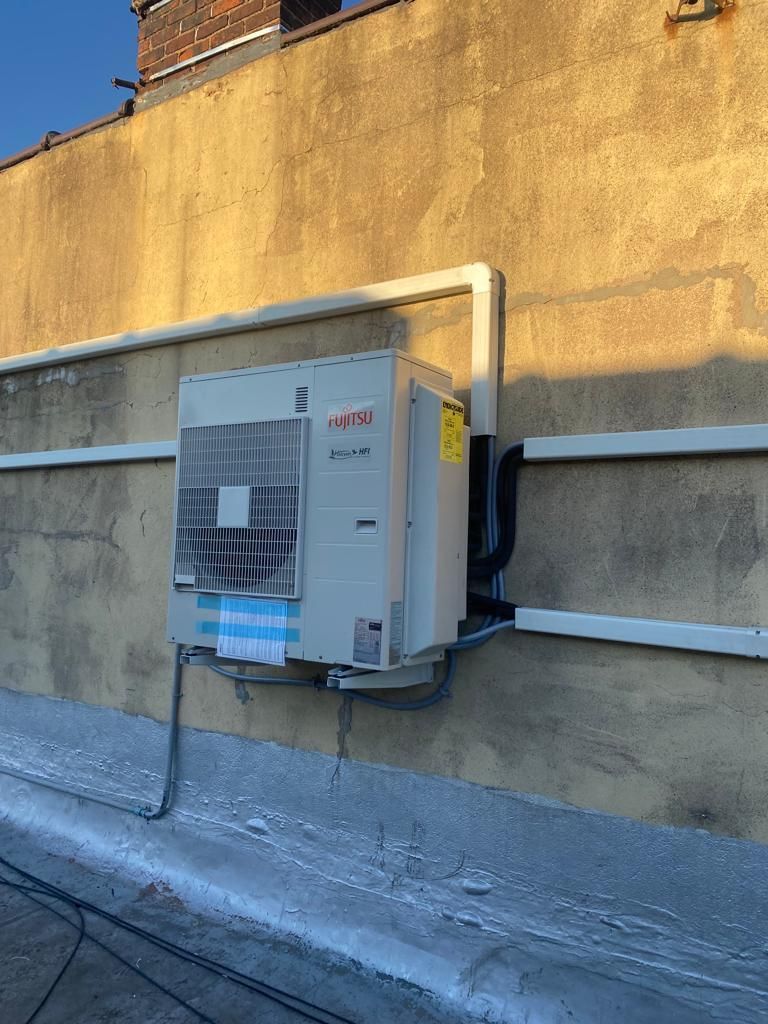 A large air conditioner is mounted on the side of a building.