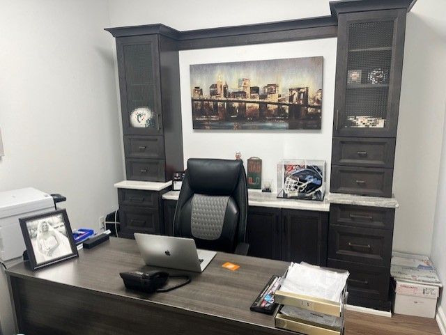 A man is sitting at a desk in an office with a laptop on it.