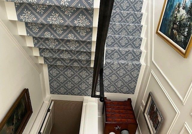 An aerial view of a staircase with a patterned carpet