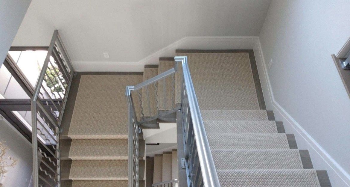 A staircase with a carpeted floor and a metal railing