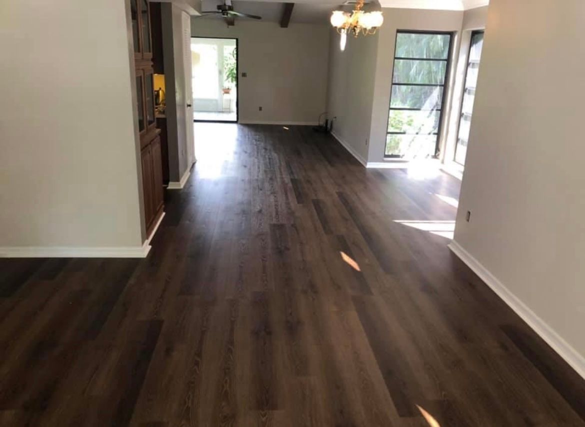 A living room with hardwood floors and a ceiling fan.