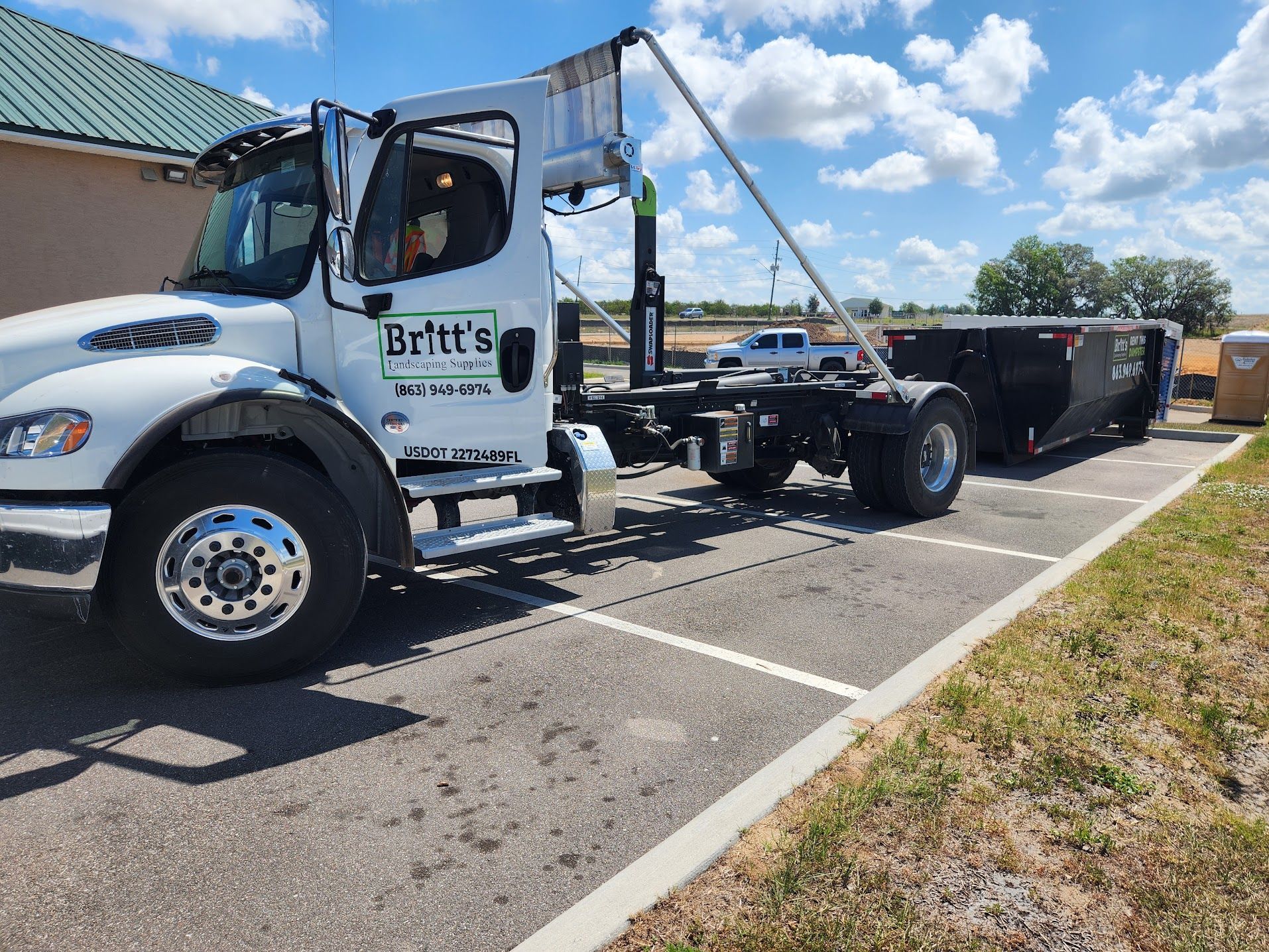 A white dump truck is parked in a parking lot.