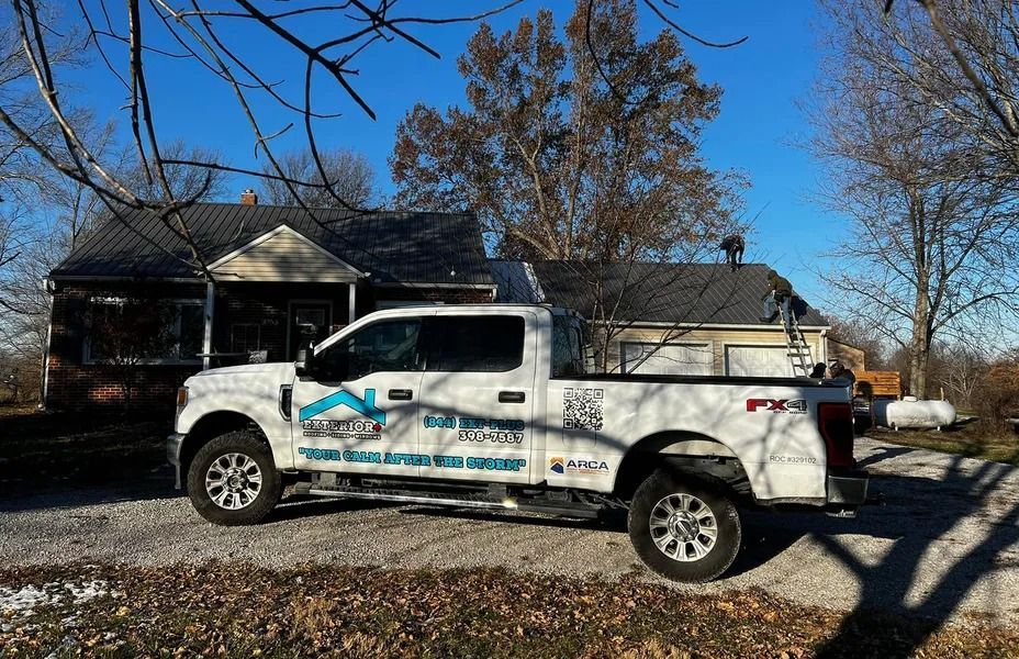 White pickup truck with blue graphics parked in front of a house on a sunny day