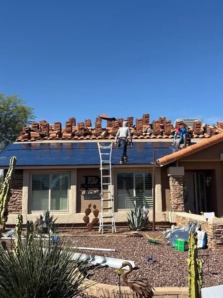 Workers installing solar panels on a desert home roof under a clear blue sky