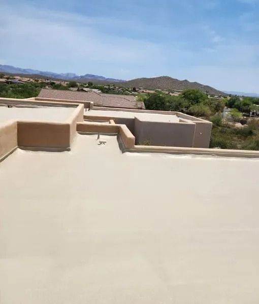Rooftop terrace with beige walls overlooking a desert landscape and distant mountains under a blue sky
