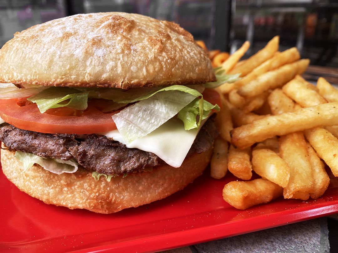 A hamburger and french fries on a red plate.