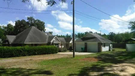 A group of houses are sitting next to each other on a lush green field.