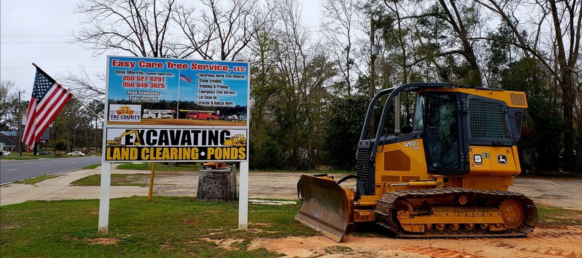 A bulldozer is parked in front of a sign that says excavating.