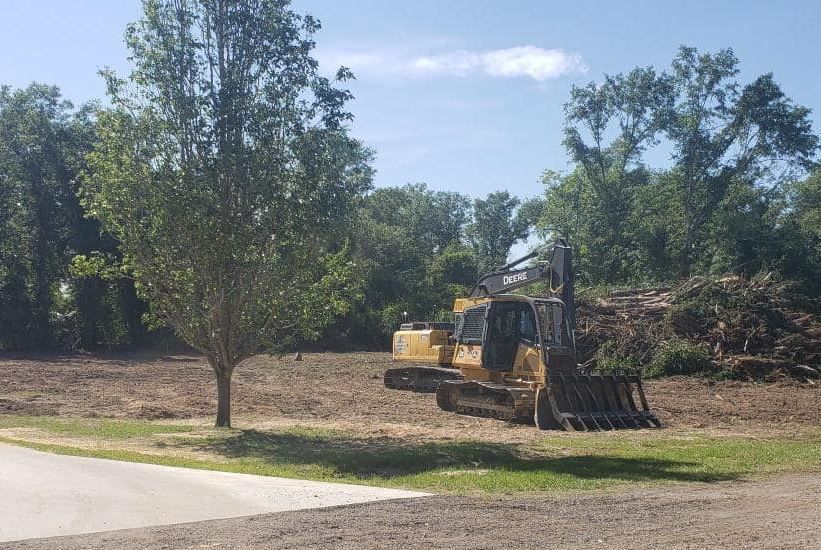 A bulldozer is sitting in the middle of a dirt field.