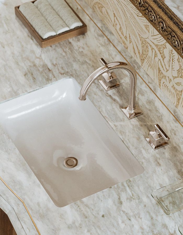 A bathroom sink with a faucet on a marble counter top.