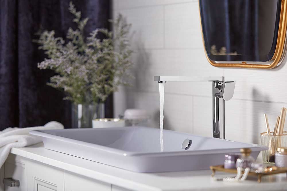 A bathroom with a sink , mirror and faucet.
