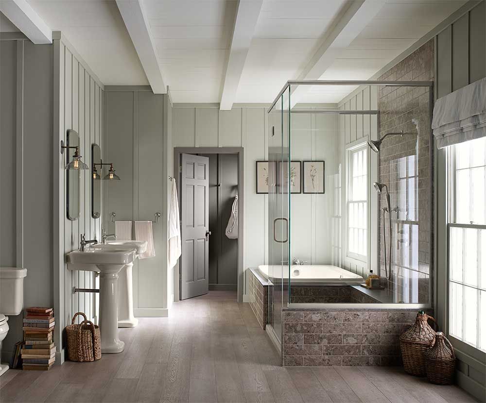 A bathroom with a sink , tub , shower and window.