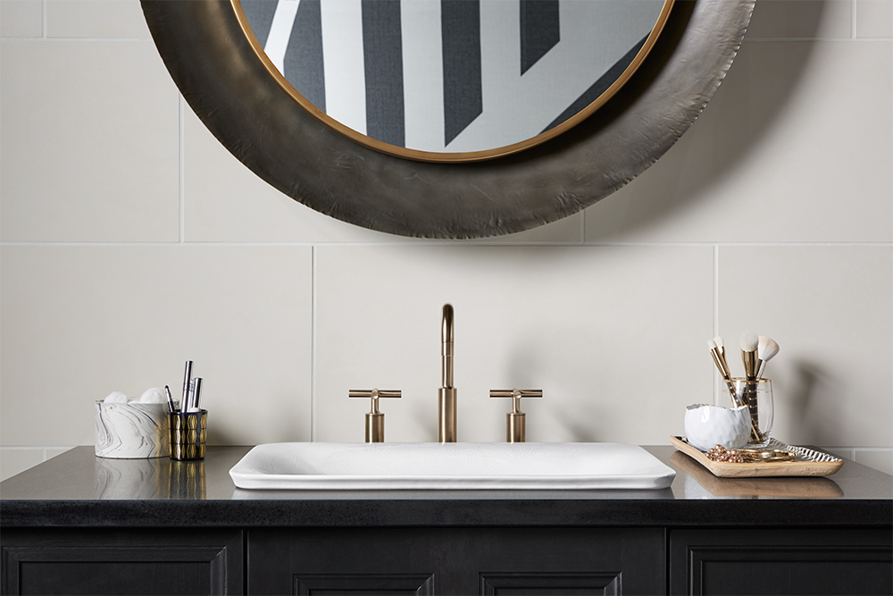 A bathroom sink with a round mirror above it