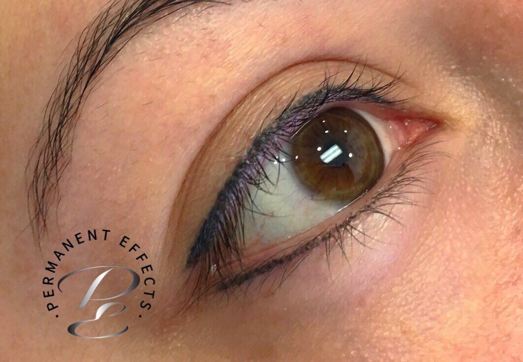 A close up of a woman's eye with permanent eye eyeliner.