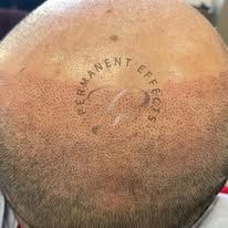 A close up of a man 's head with a tattoo on it.