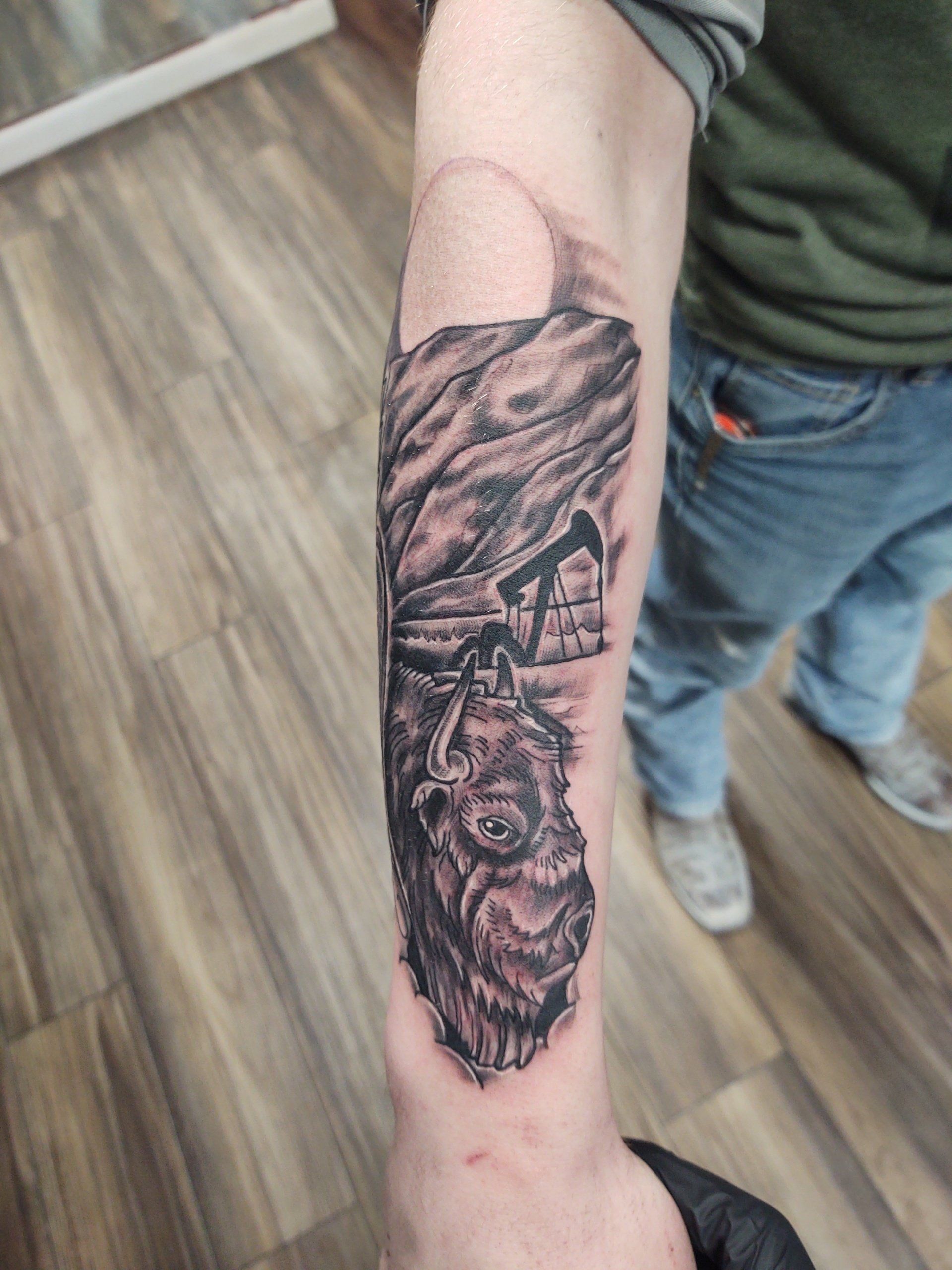 A person has a tattoo of a wolf on their forearm