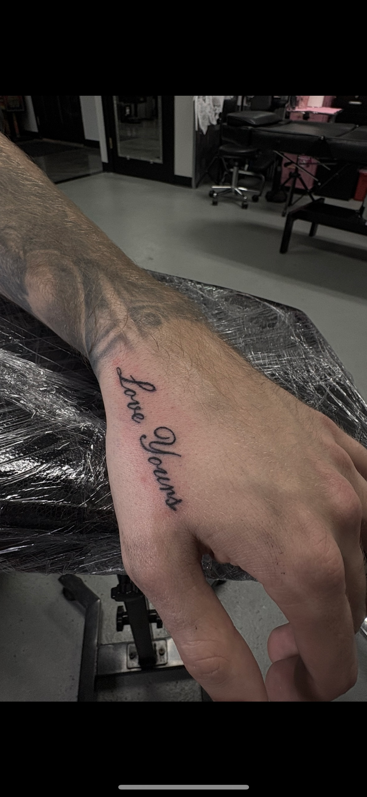 A close up of a person 's hand with a tattoo on it.