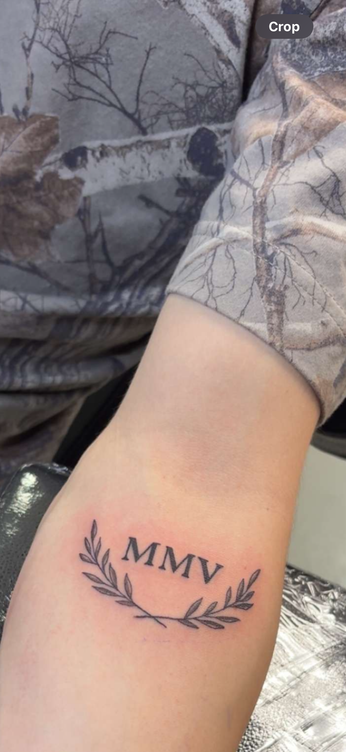 A person has a tattoo on their arm that says mmv.