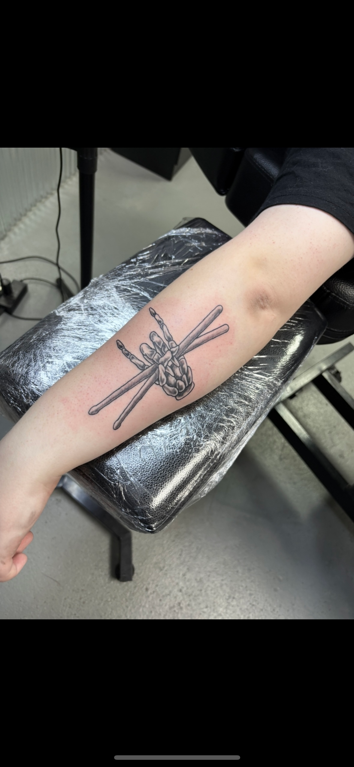 A person is getting a tattoo on their forearm.