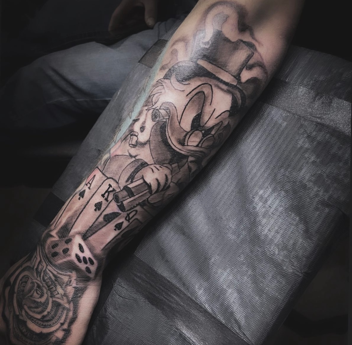 A tattoo of a hummingbird and a rose on a persons arm