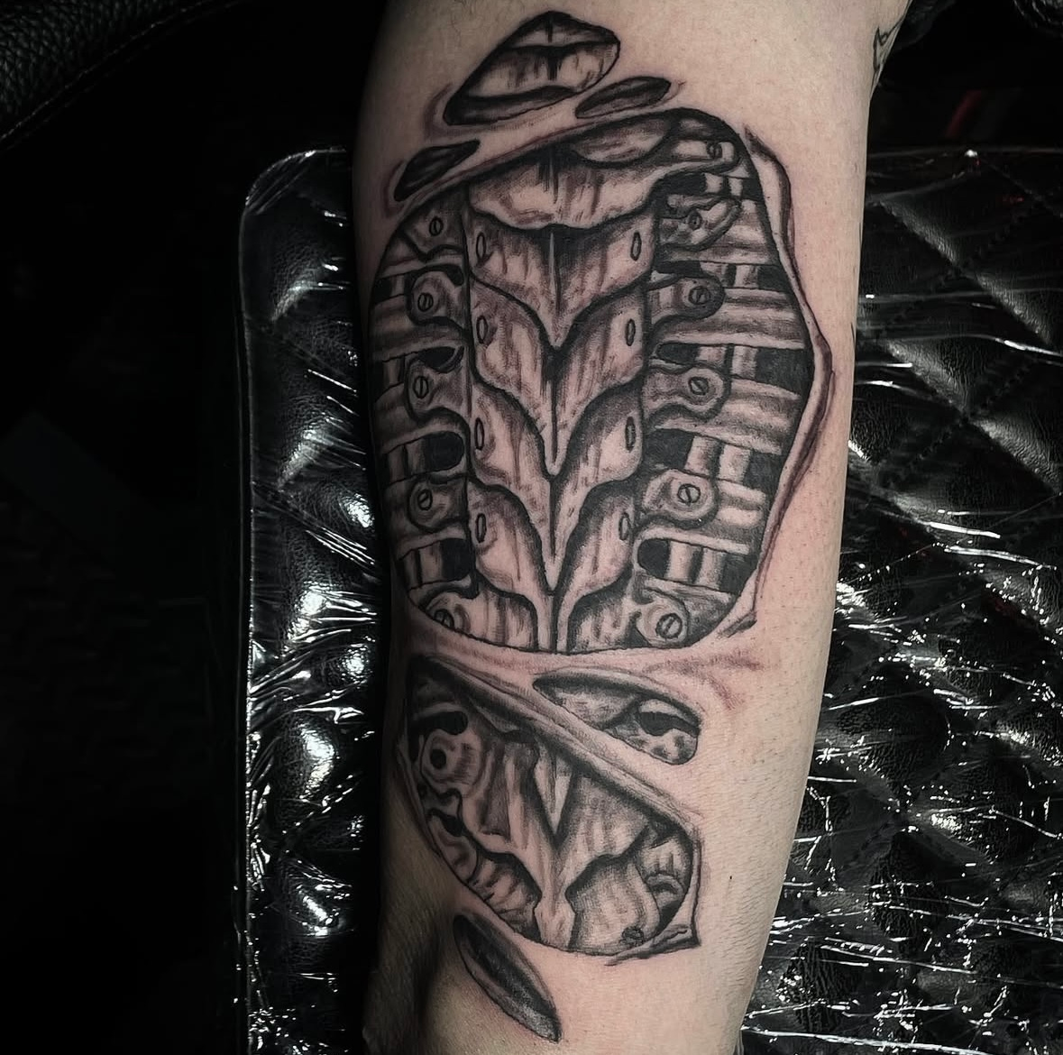 A black and white tattoo of a butterfly on a person 's arm