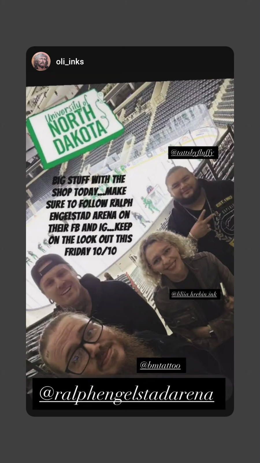 Group selfie at the University of North Dakota arena. Sign reads Ralph Engelstad Arena.