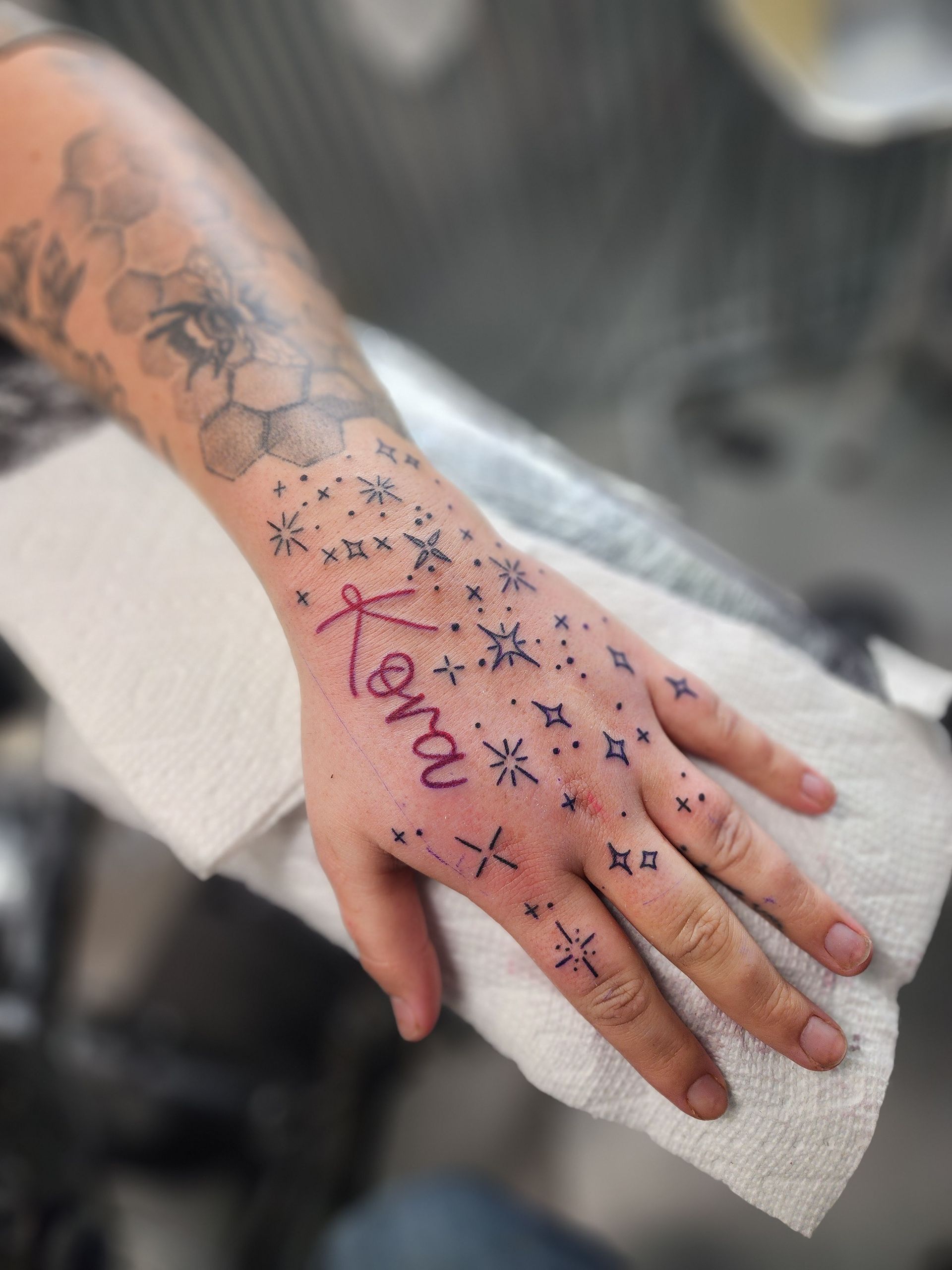 Hand with a fresh tattoo: stars, name