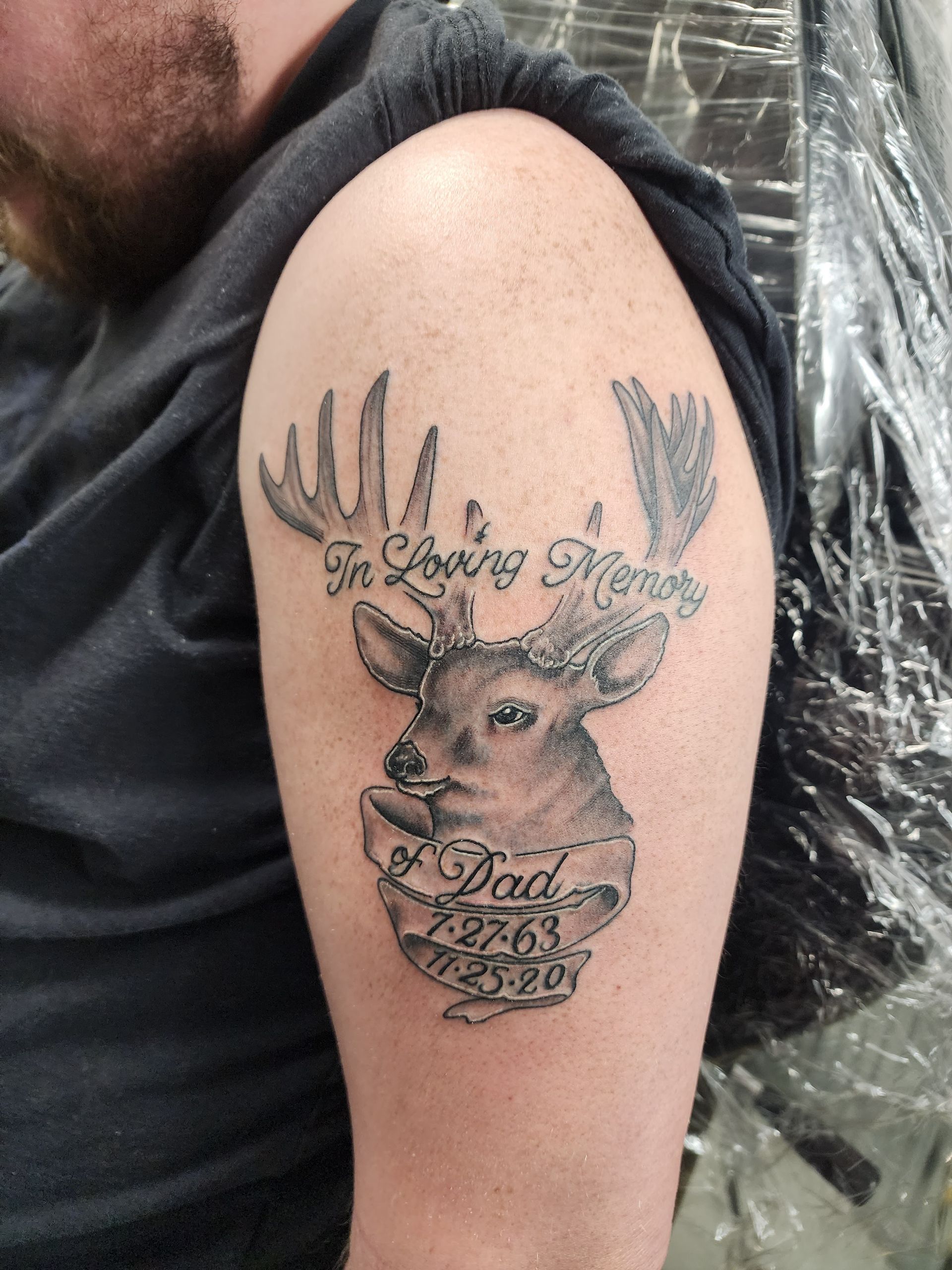 Tattoo of a deer head with antlers and banner.