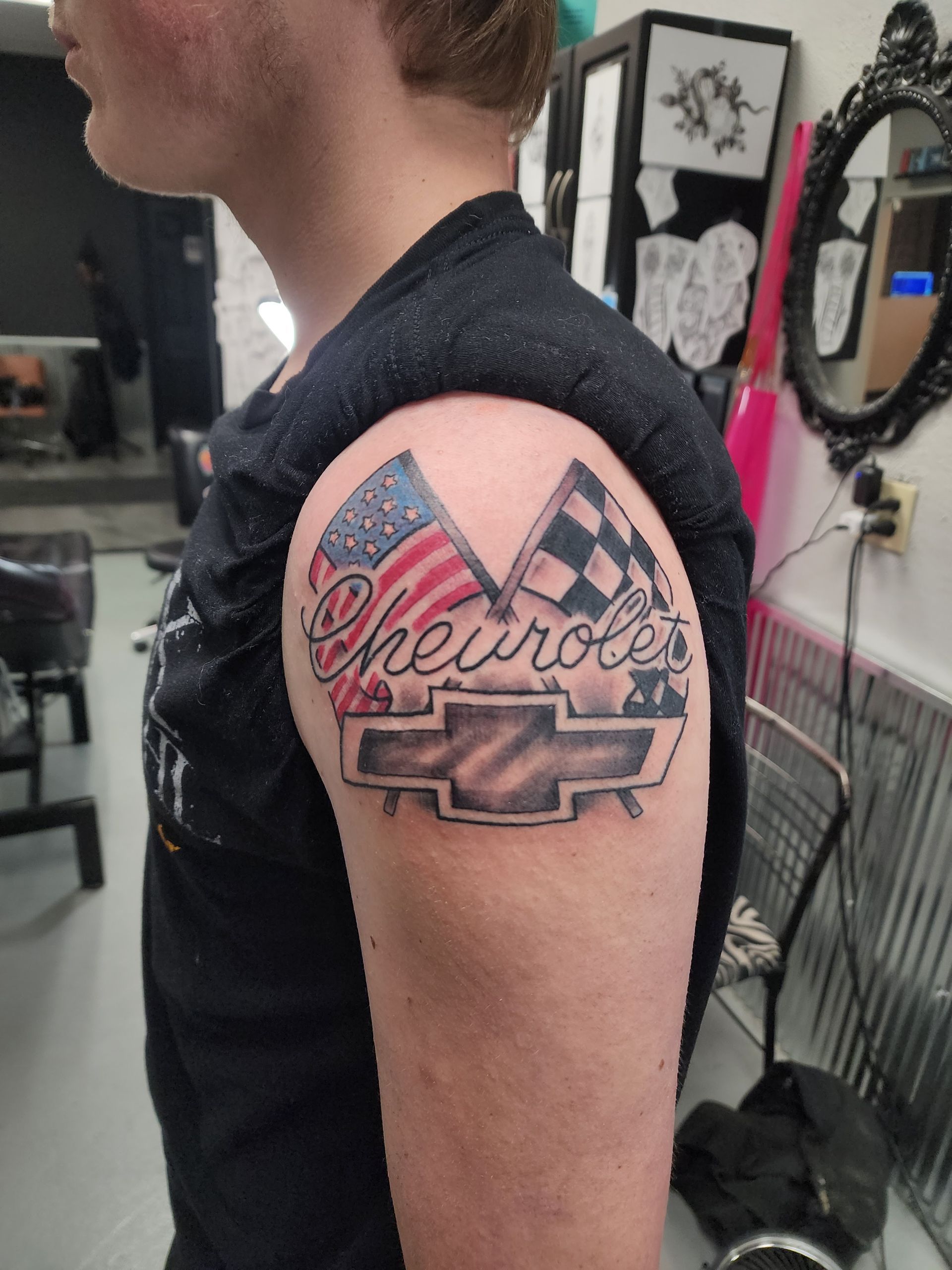 Tattoo on arm features US flag, checkered flag,