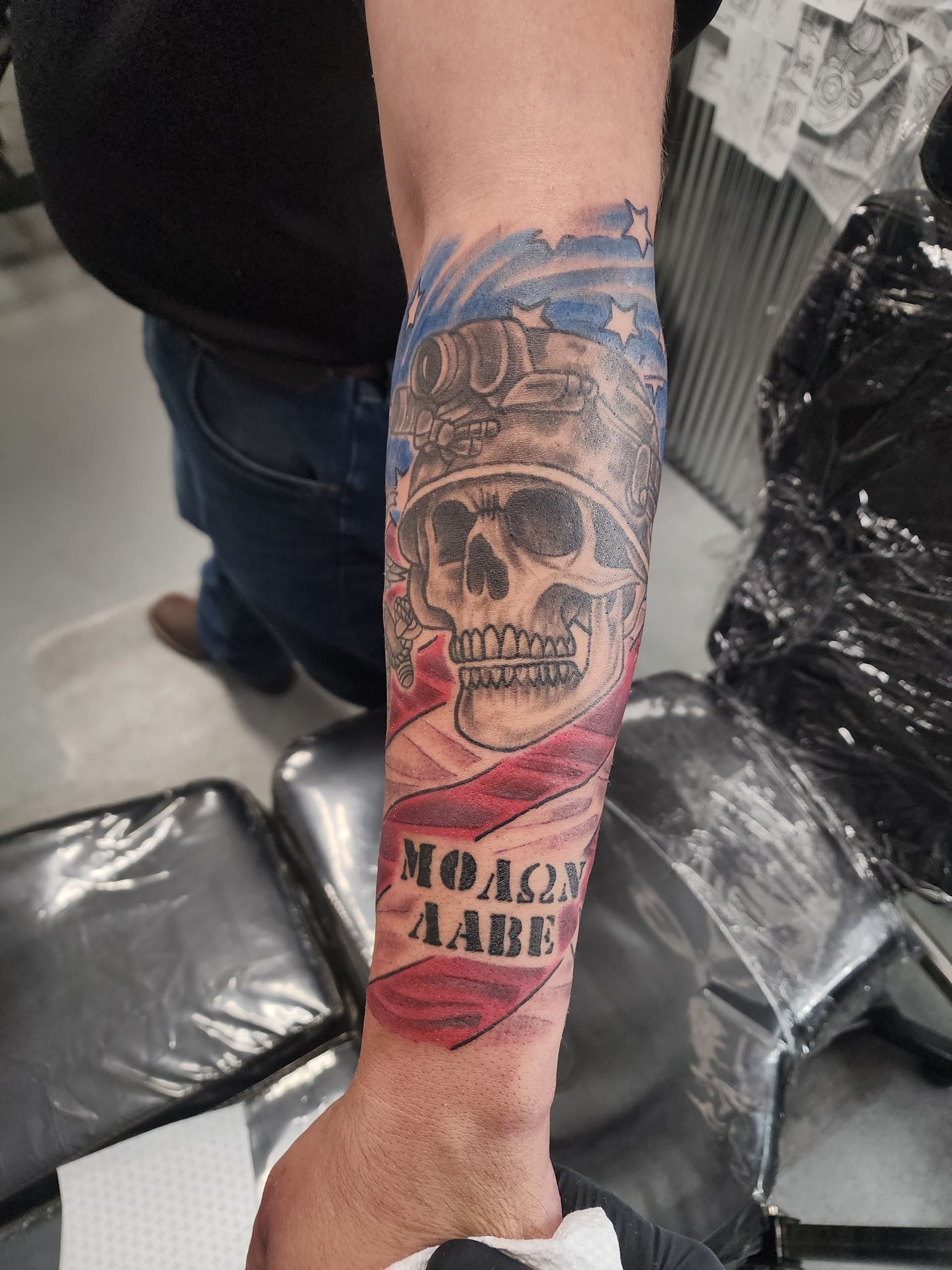 Tattoo on forearm: skull, American flag, 