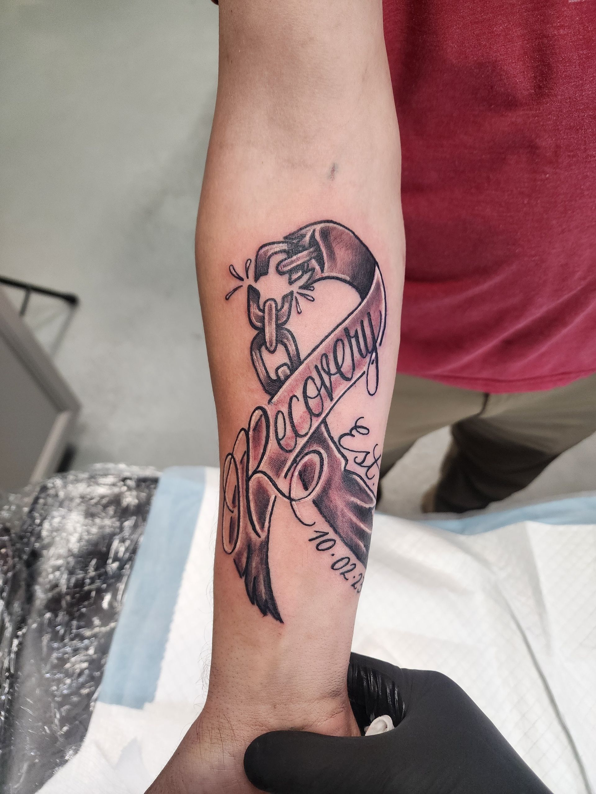 Tattoo of a ribbon with the word 