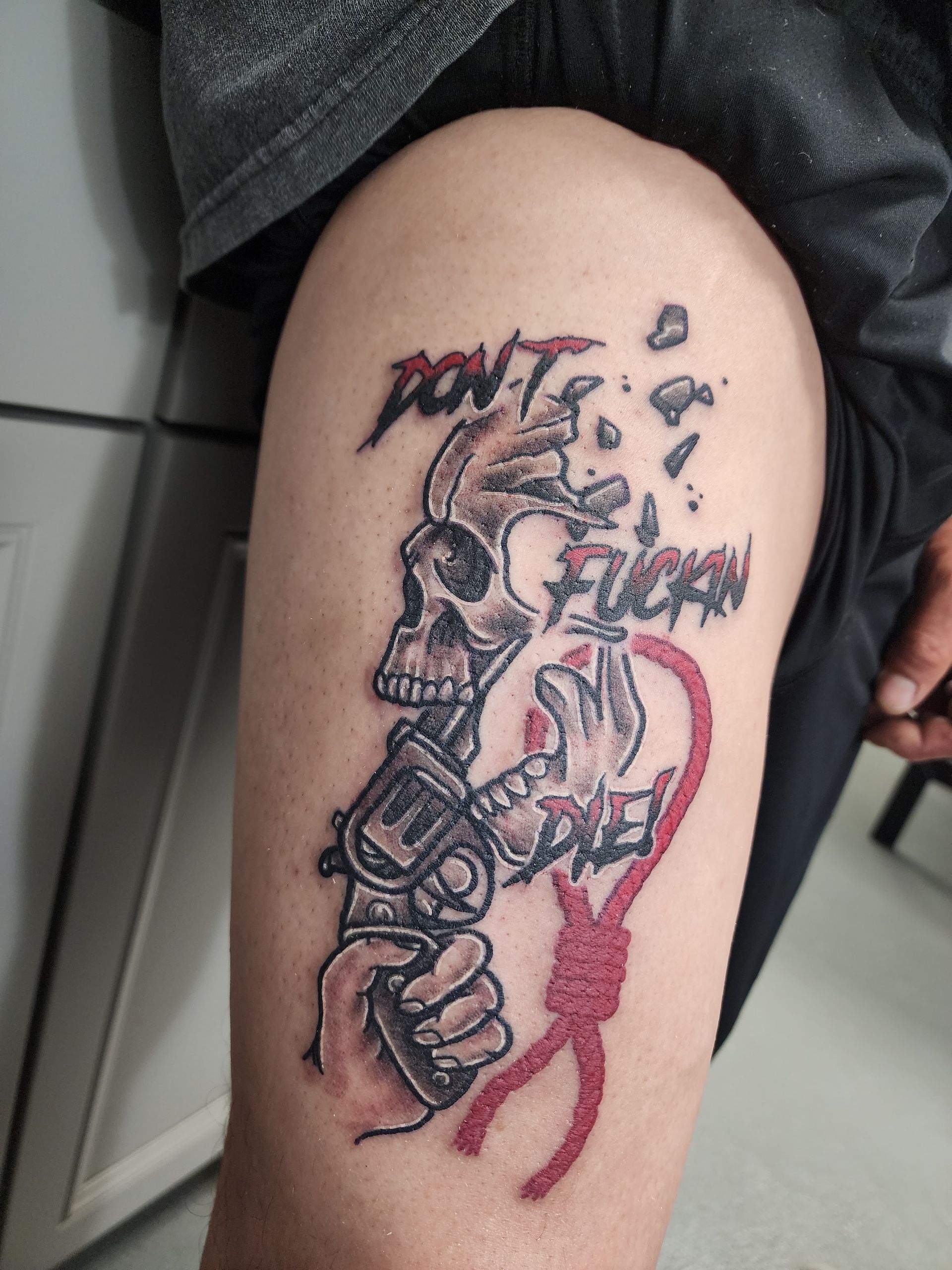 Tattoo on leg: Skull, gun, and noose with 