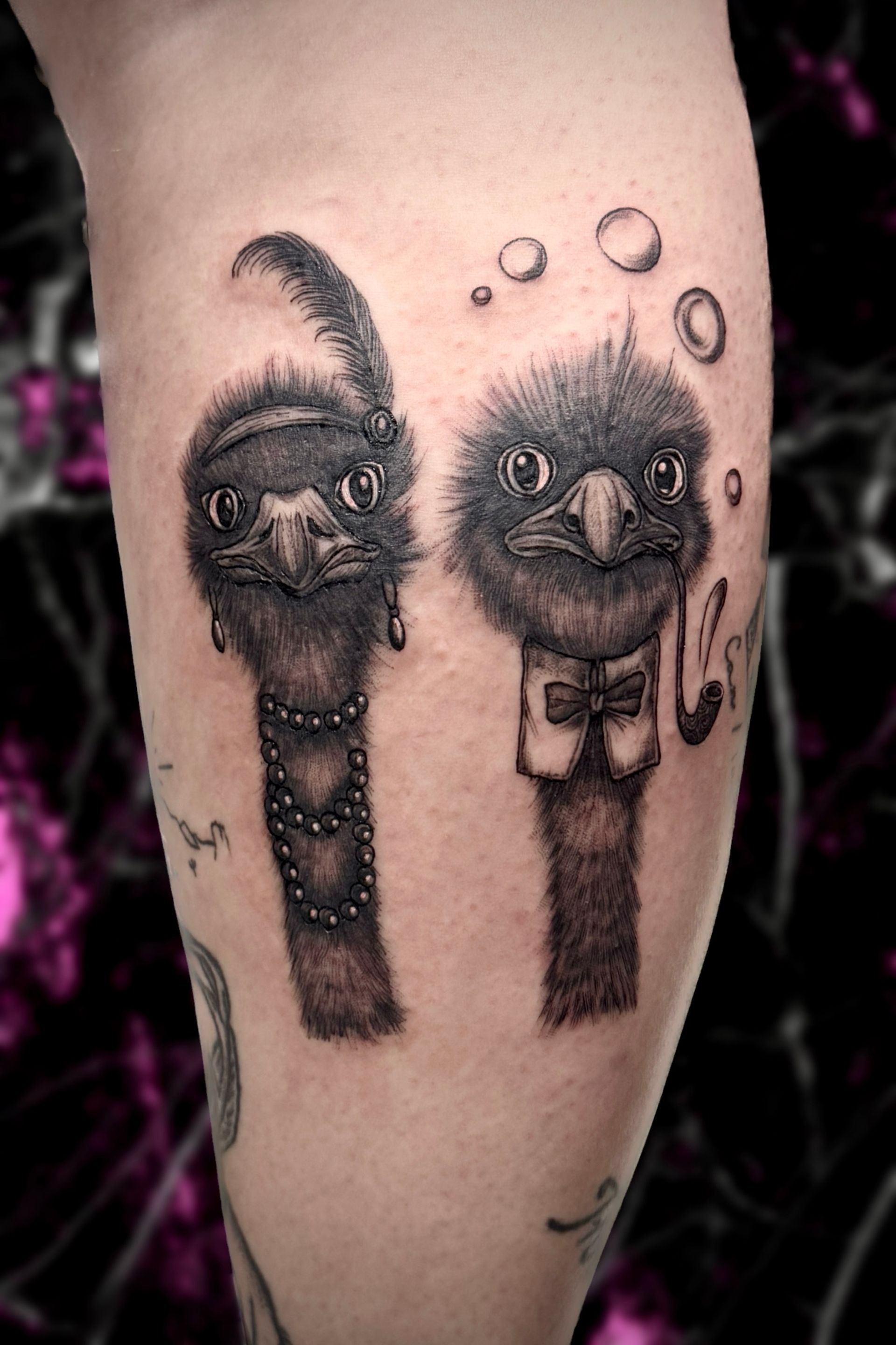 Tattoo of two stylized emus one with jewelry, the other wearing a bow tie and holding a smoking pipe.