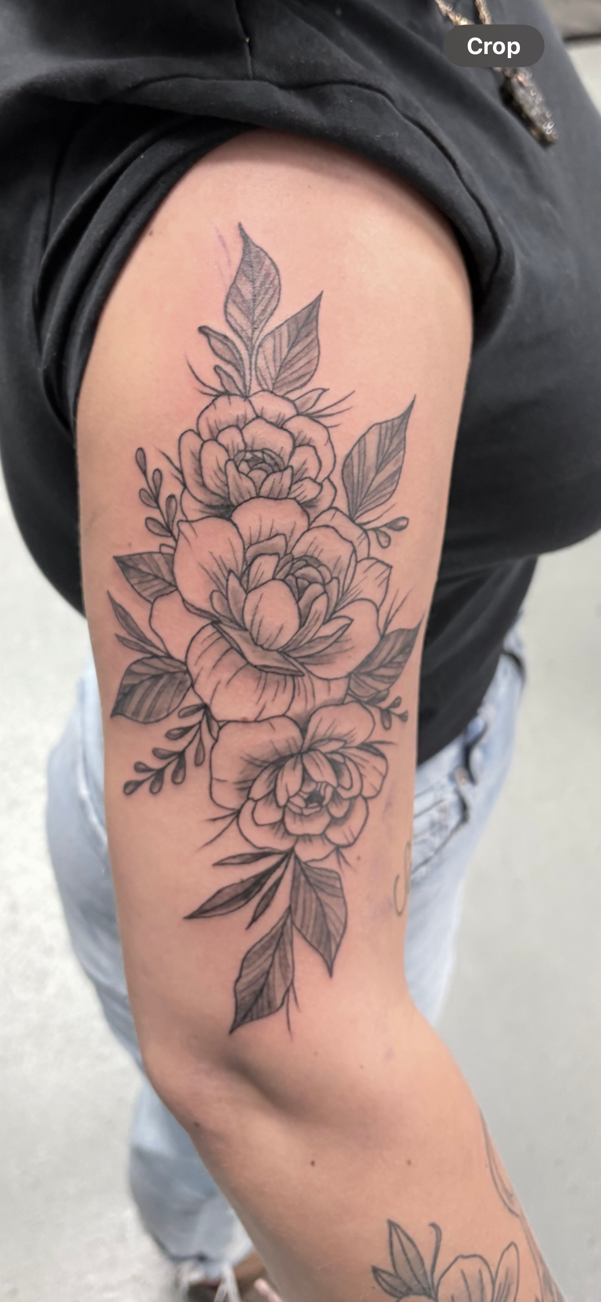 A woman has a tattoo of flowers on her arm.