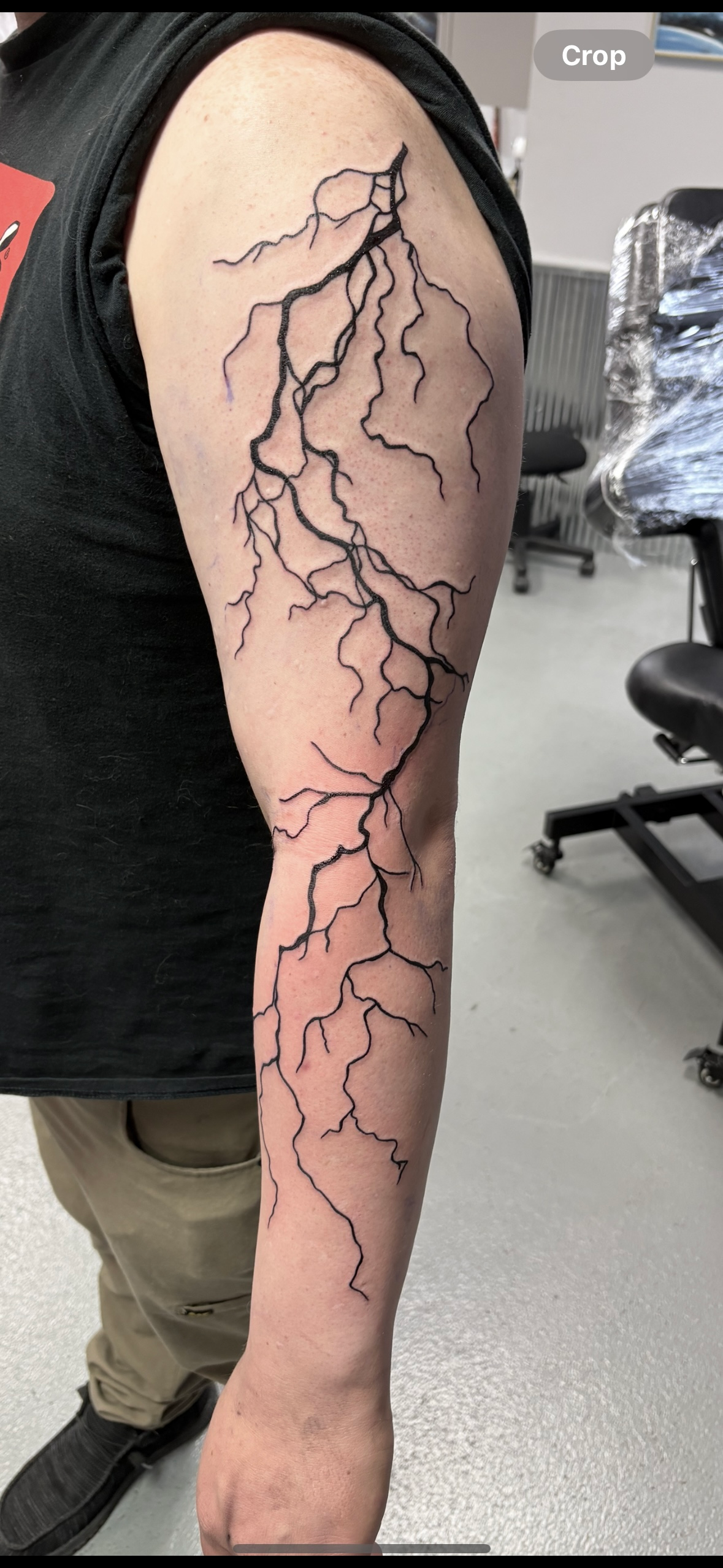 A person with a tattoo of lightning on their arm
