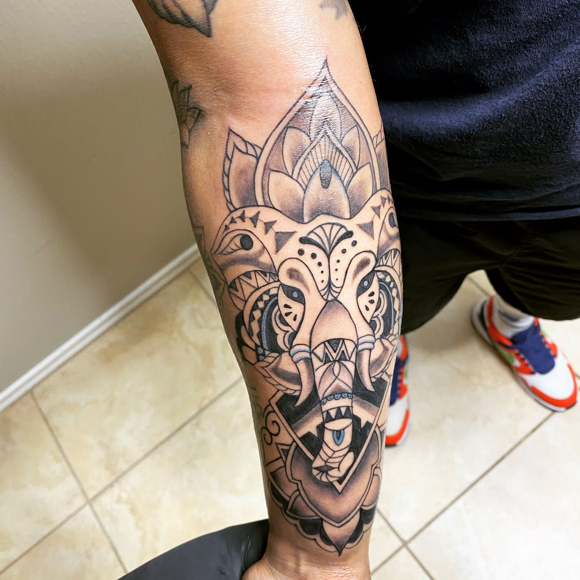 Tattoo of an ornate elephant design on a person's forearm. Black ink, intricate patterns, and geometric shapes.