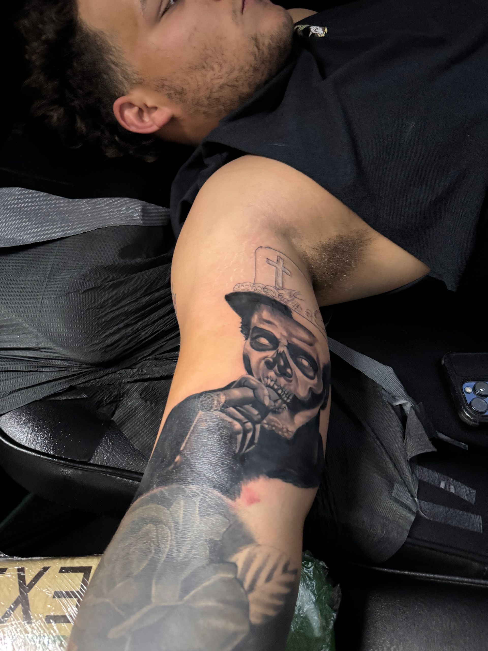 Man getting a black and gray forearm tattoo. Portrait of a man on the upper arm.