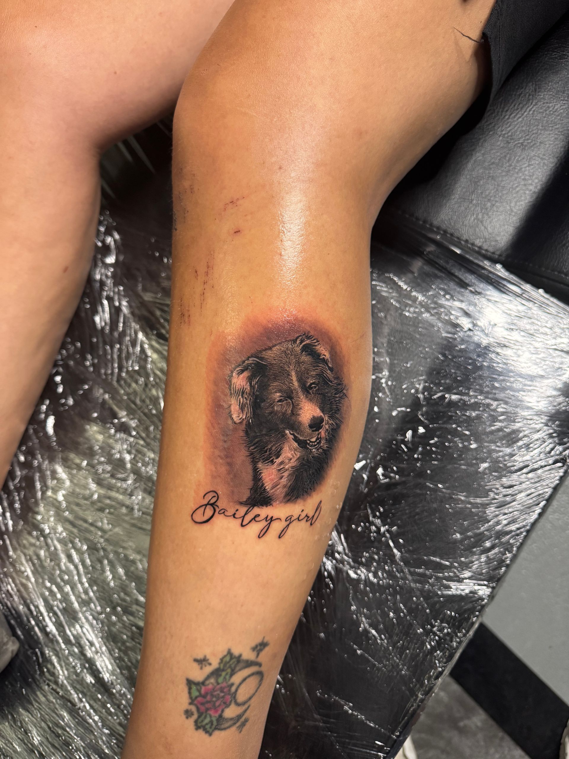 Tattoo of a dog's face on a leg, with the name