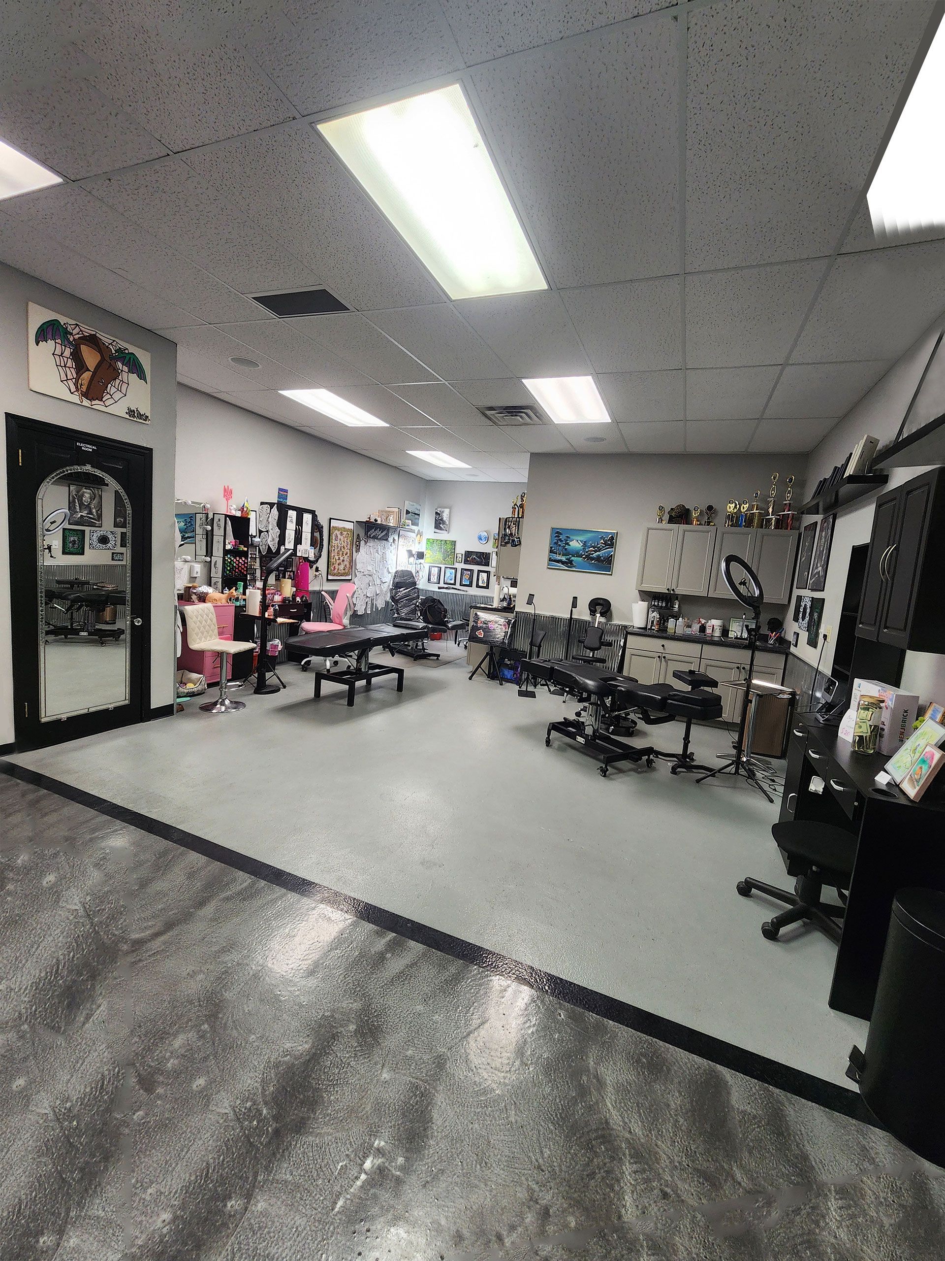 A black chair is sitting in a room with a lot of pictures on the wall