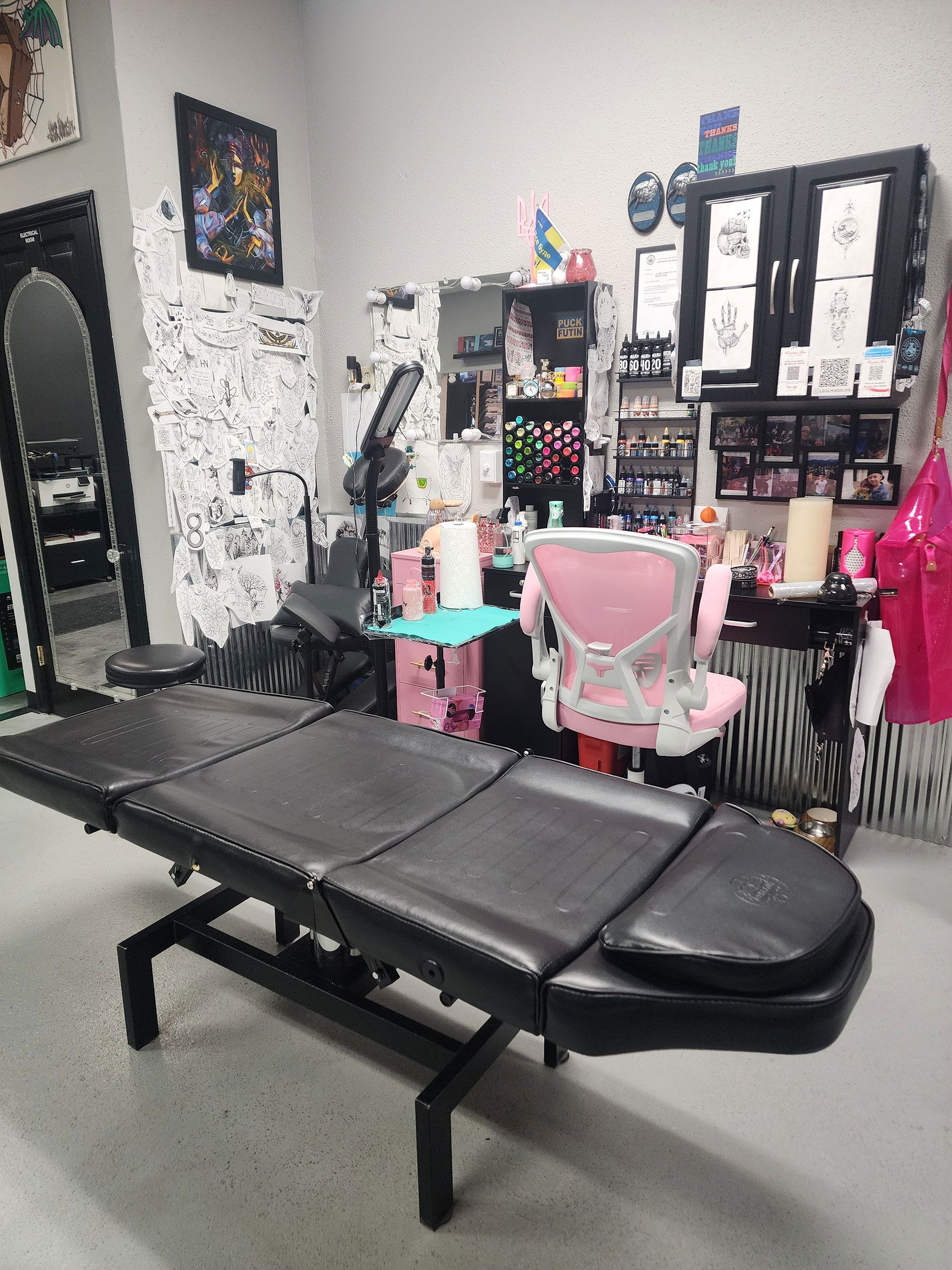 A tattoo parlor with a bed and chairs in it