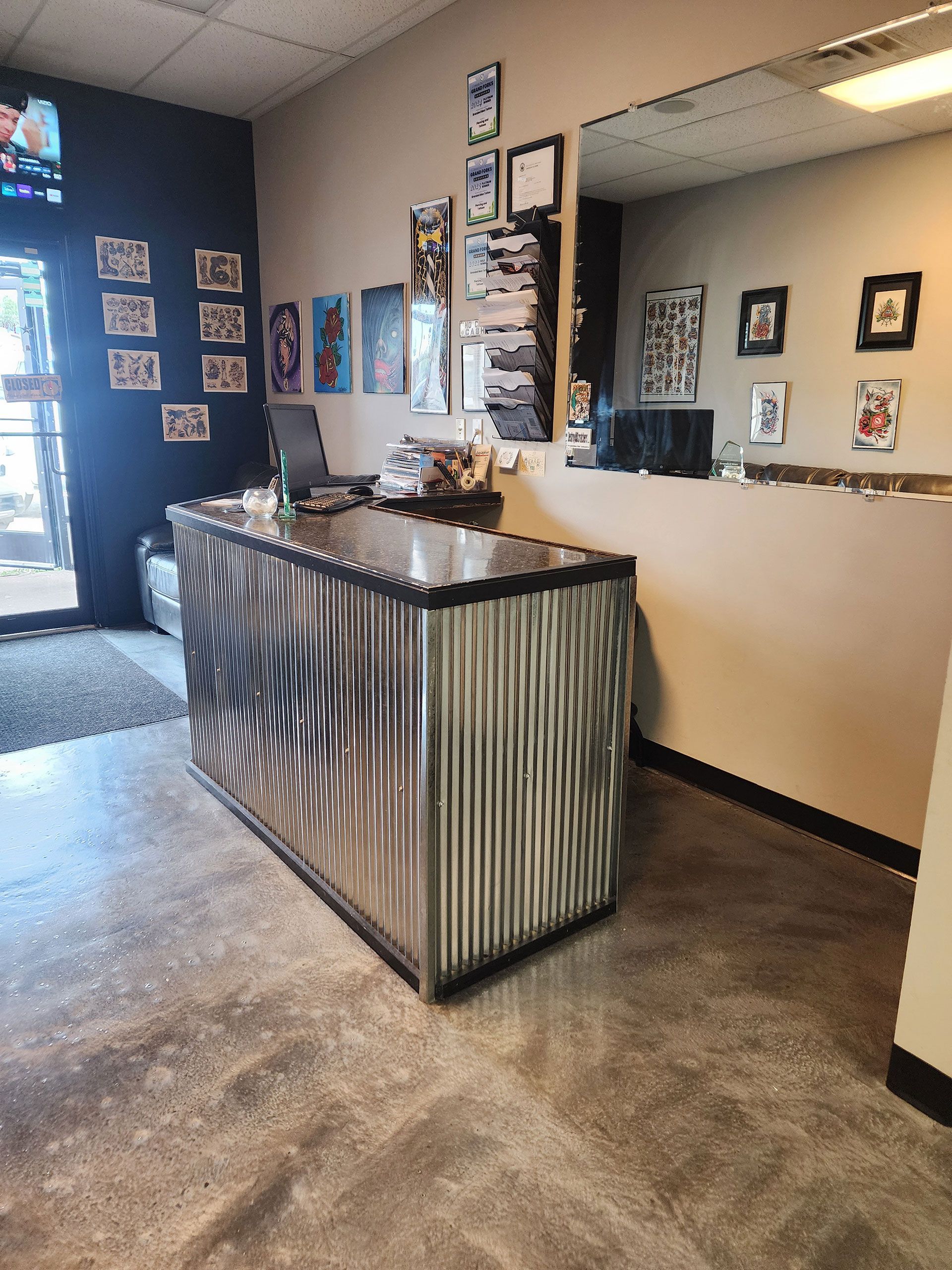 A reception desk in a room with a lot of pictures on the wall.