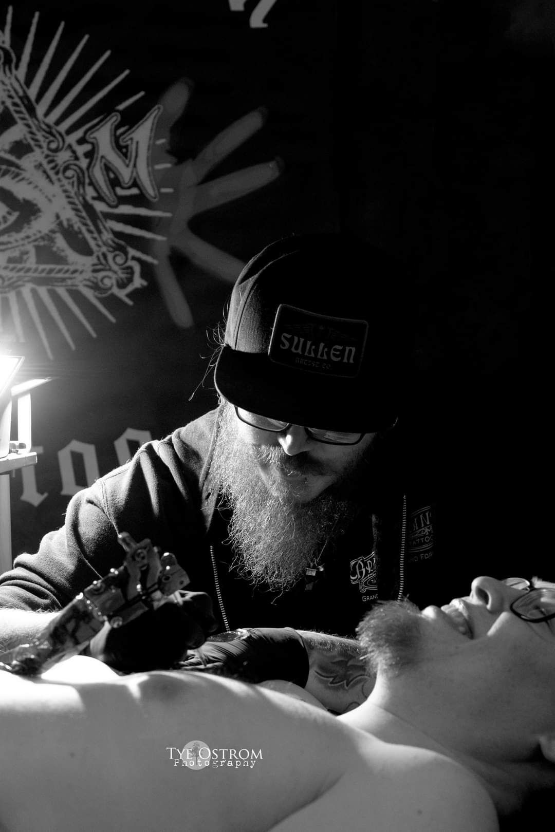 Isaac is tattooing a man chest