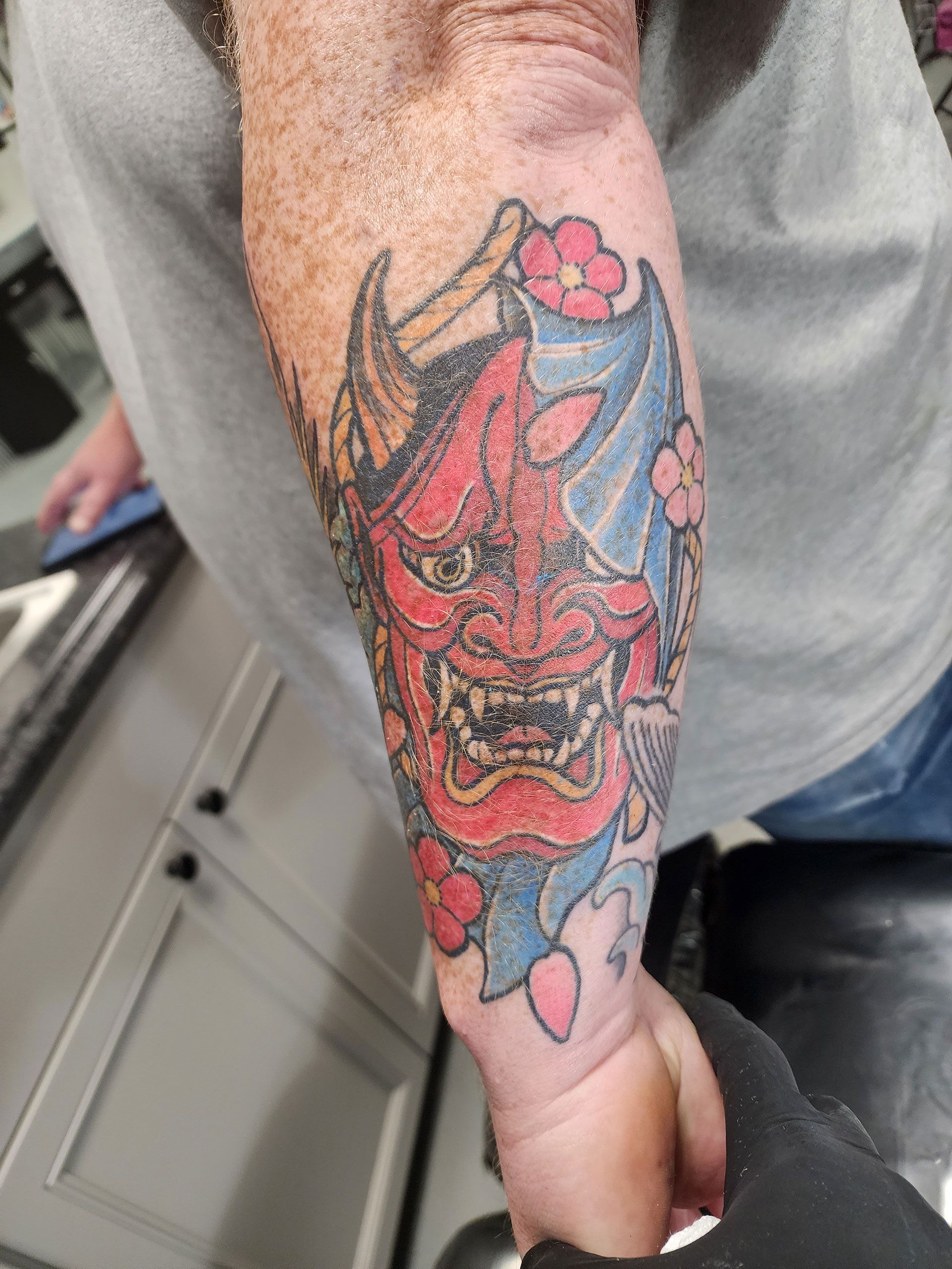 A man has a tattoo of a demon on his arm